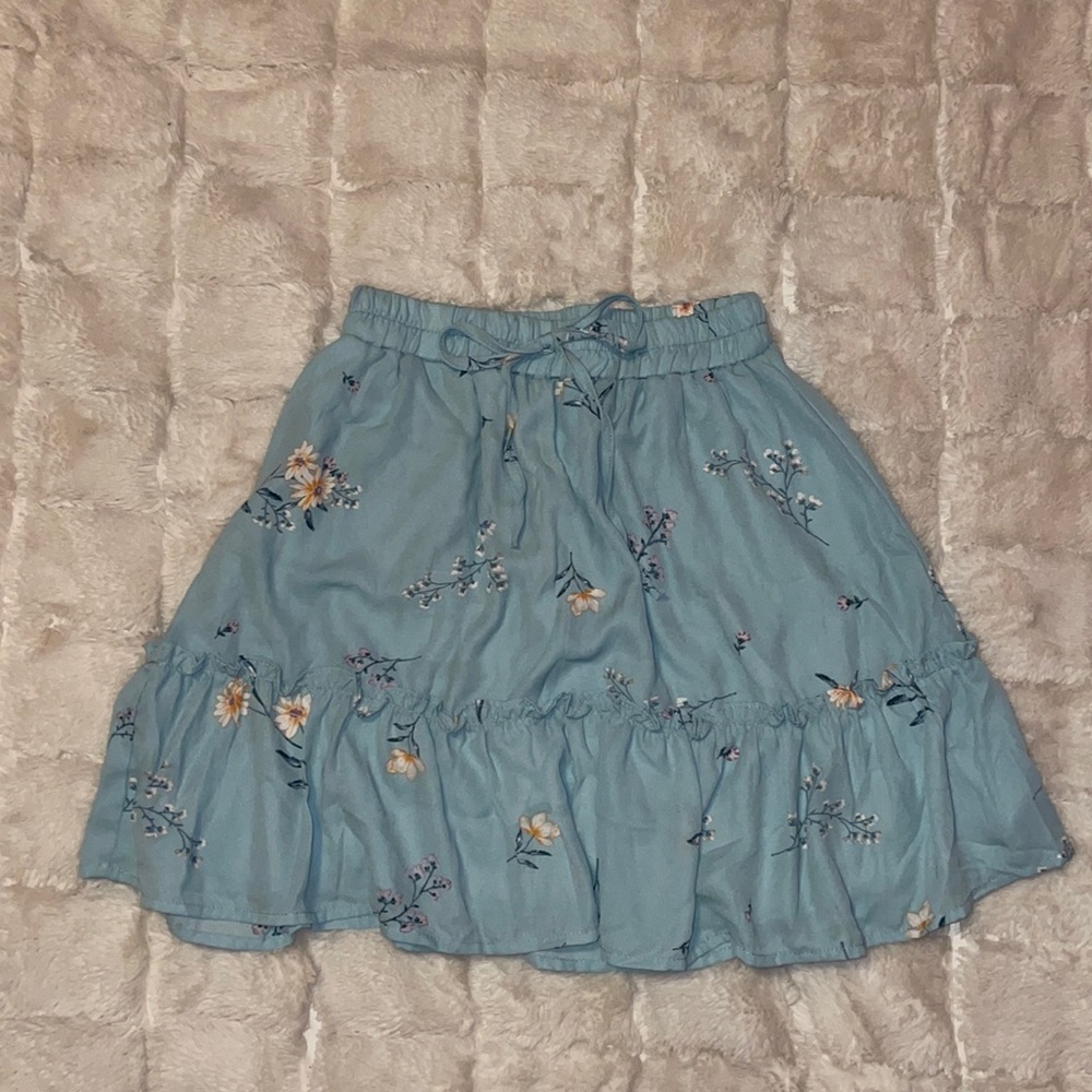 Elastic banded blue floral skirt with tie, with ruffles along the seam.